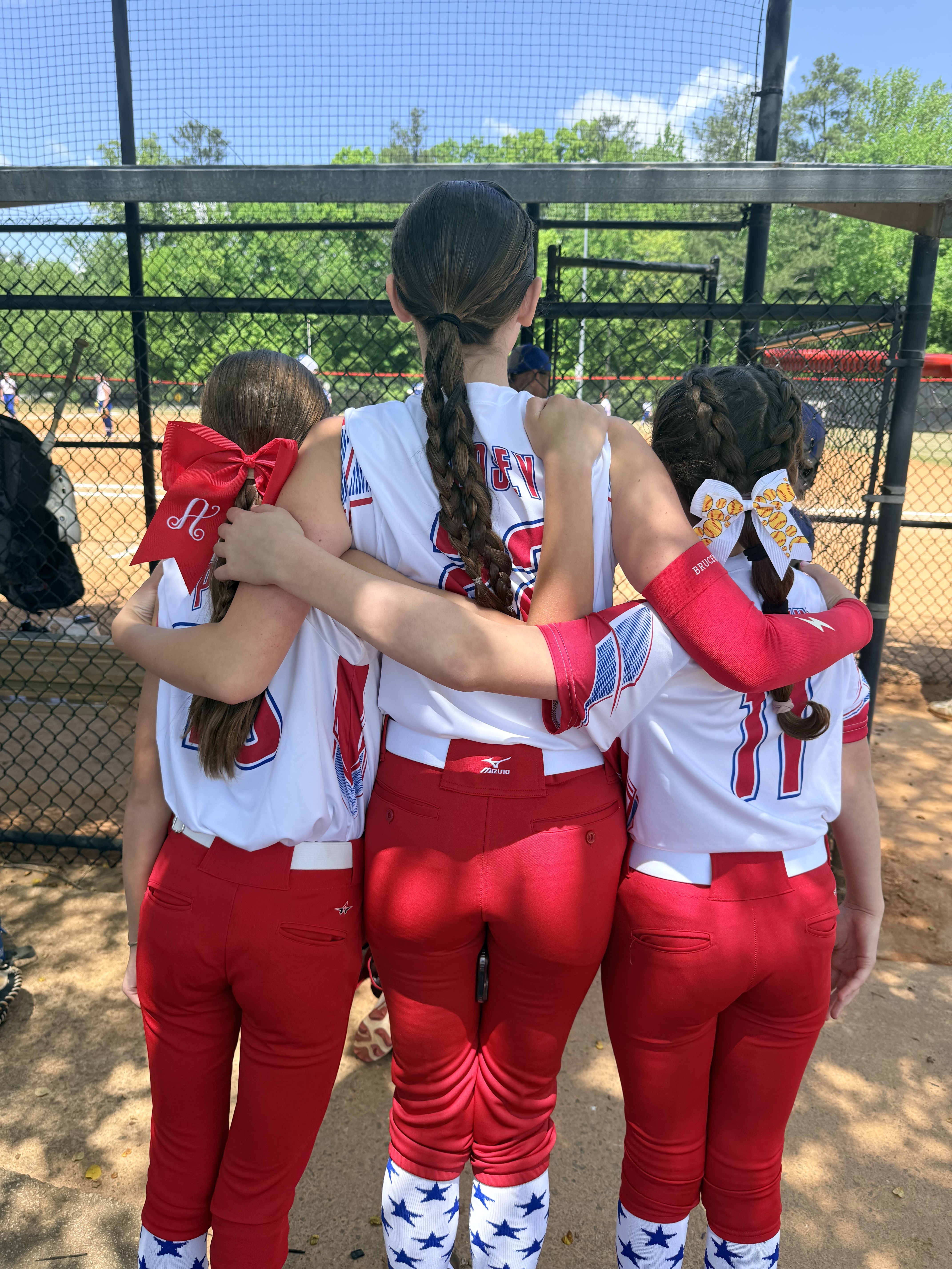 Three softball teammates in red pants